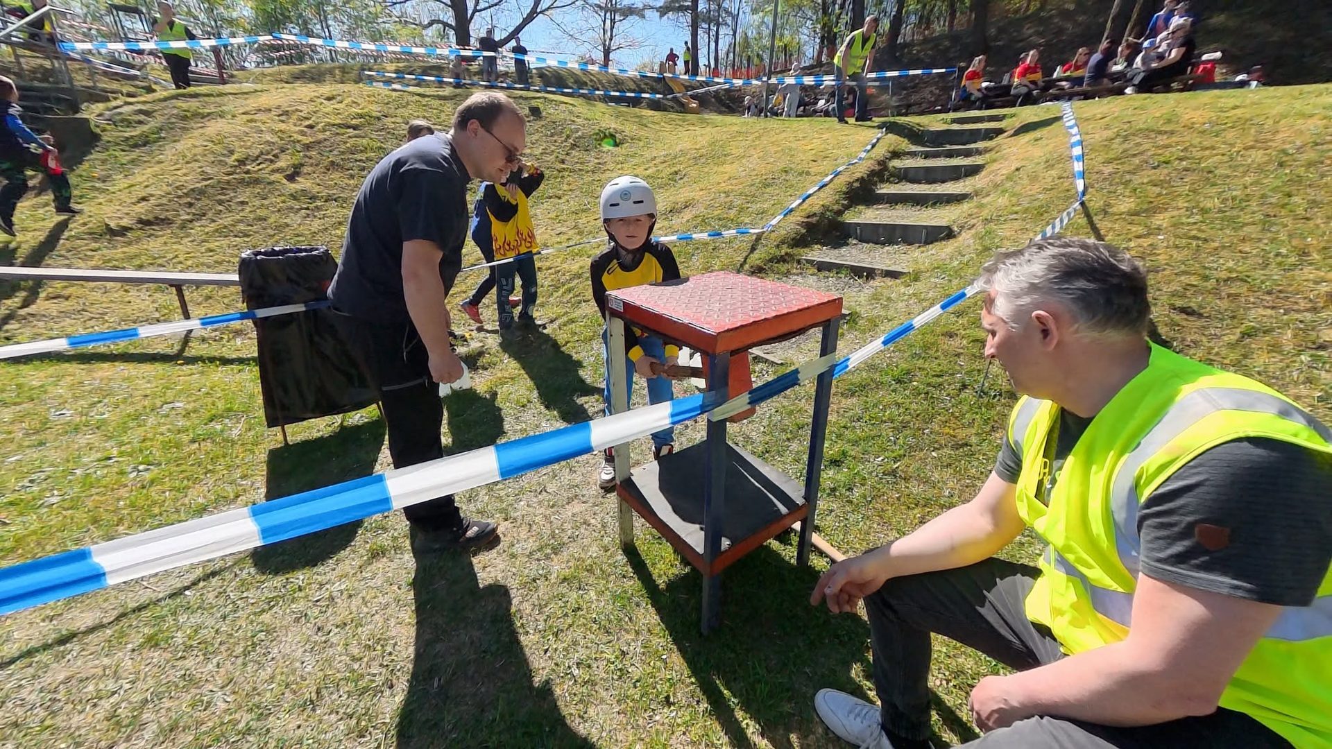 Mladý závodník u překážky za podpory vedoucího